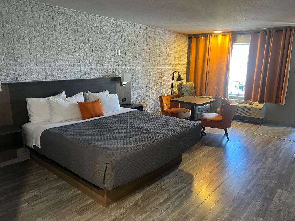 a hotel room with a large bed and a desk at Complexe Dix80 in Mont-Laurier