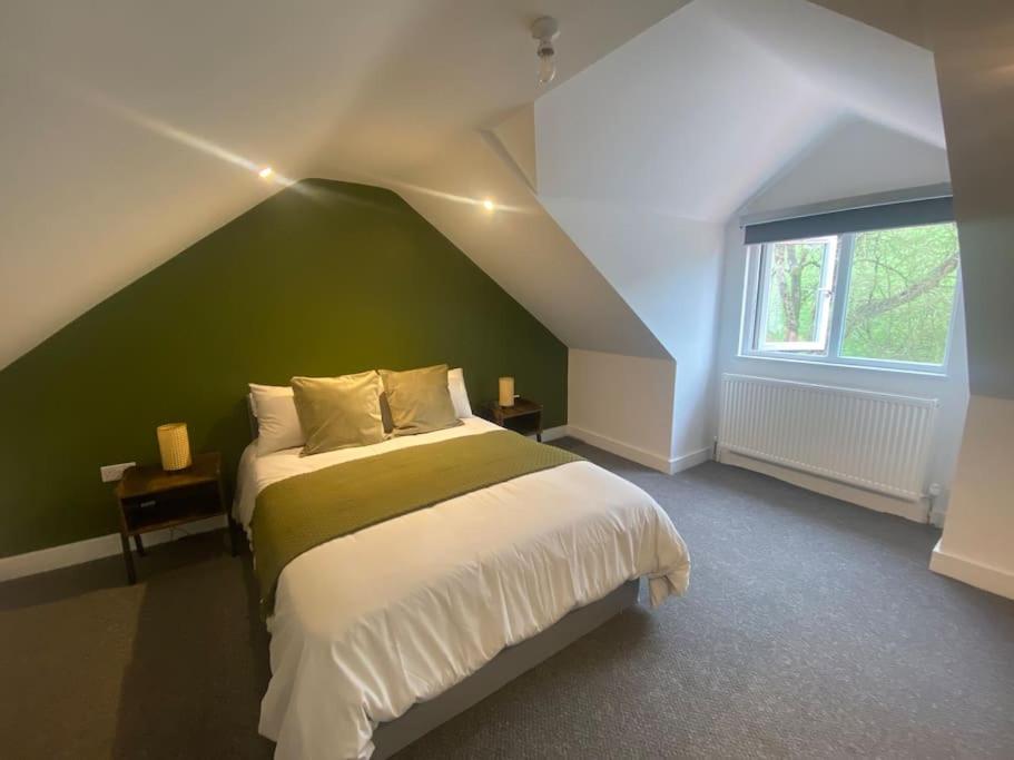 ein Schlafzimmer mit einem großen Bett und einer grünen Wand in der Unterkunft 17A Stella house nr Bath in Radstock