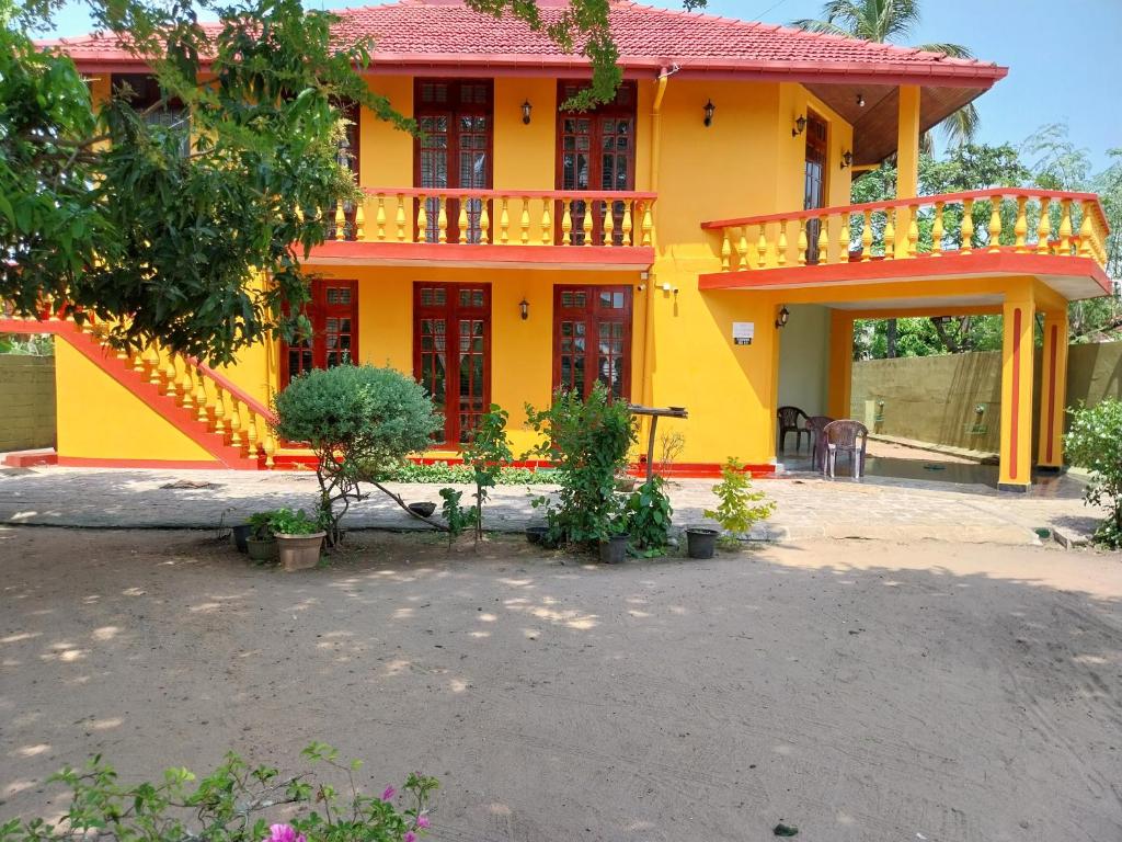 a yellow house with a red roof and a balcony at Villa Roma - Negombo in Negombo