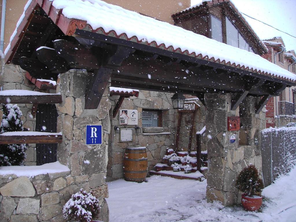 a snow covered building with a parking sign in front of it at Hotel Rural El Yantar de Gredos in San Martín del Pimpollar