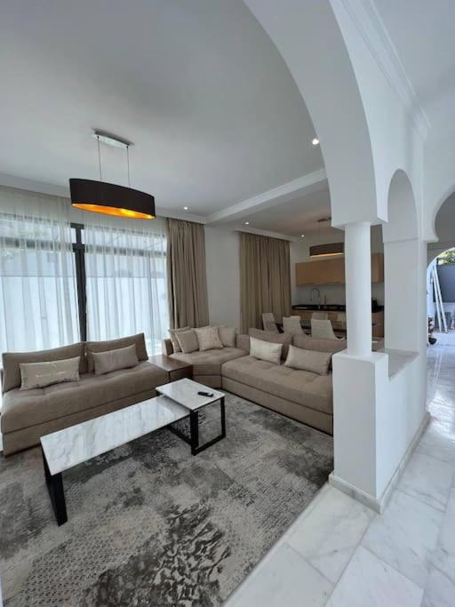 een grote woonkamer met banken en een tafel bij Luxury villa Near The Beach in Temara