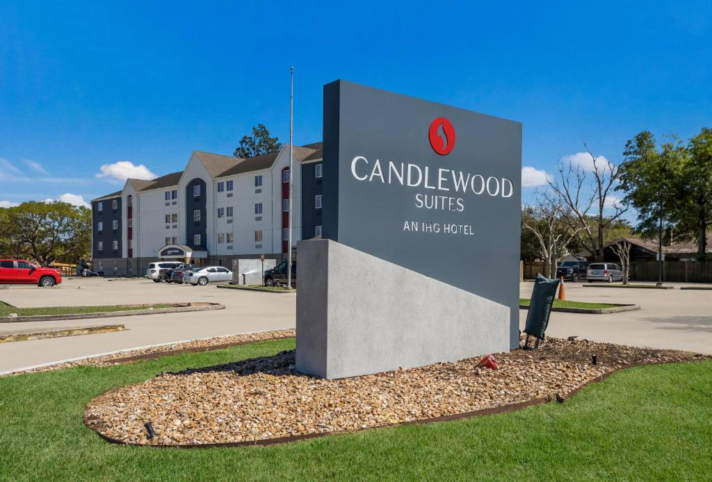 una señal para suites de madera de canela en un estacionamiento en Candlewood Suites Lafayette - River Ranch, an IHG Hotel, en Lafayette