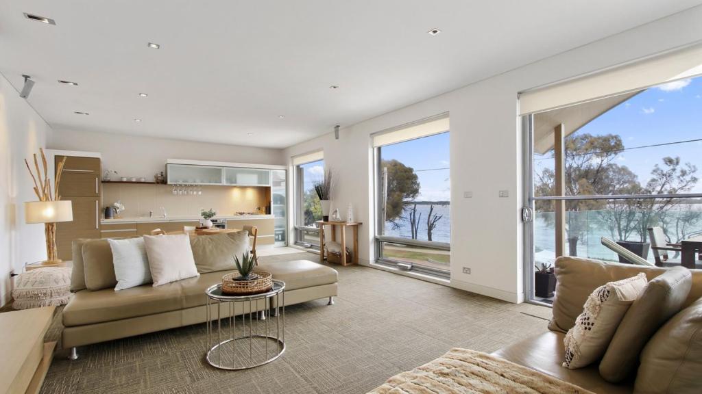a living room with a couch and a table at Lake Suite Metung - Couples Lakeside Escape in Metung