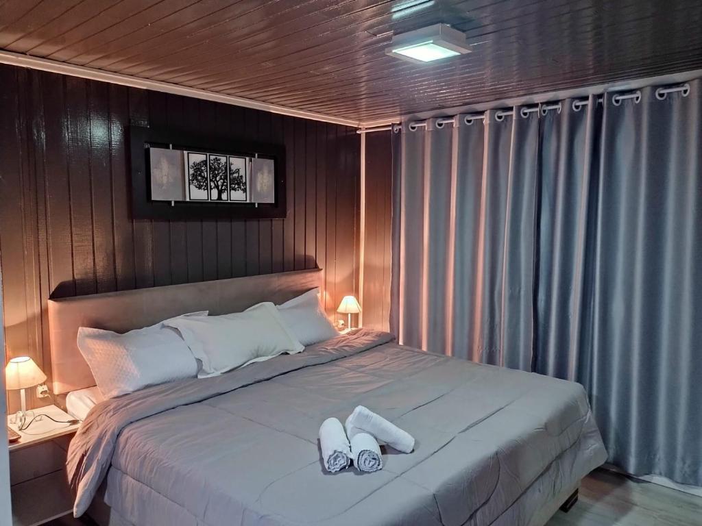 1 dormitorio con 1 cama con 2 zapatillas en Chalé D´Roos III en Canela