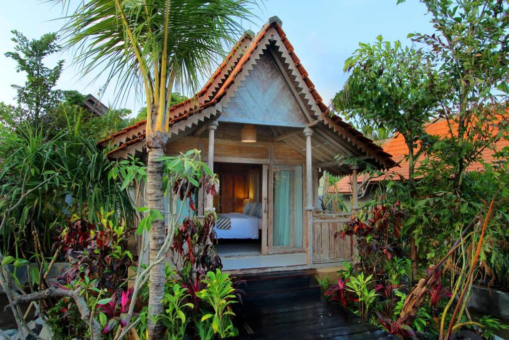 a guest house in the middle of a garden at Outpost Ubud Bungalows in Ubud