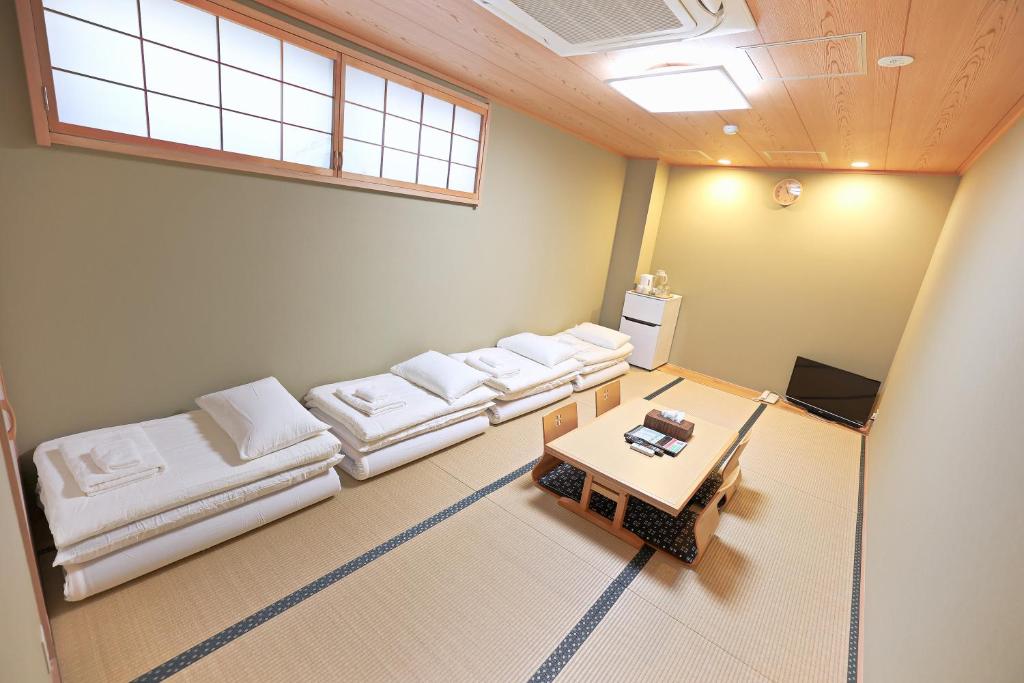 uma sala de estar com sofás brancos e uma mesa em Akihabara Nakagawa Inn em Tóquio