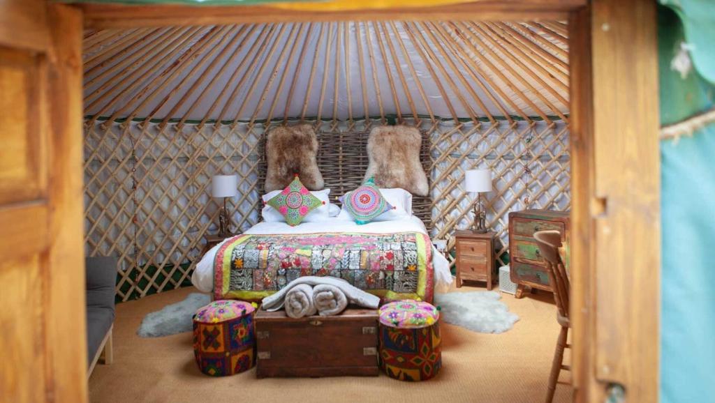 a bedroom with a bed in a yurt at HAYNE BARN ESTATE - 2 Luxury heated Yurts - private hot tub- private bathroom and kitchen in Hythe