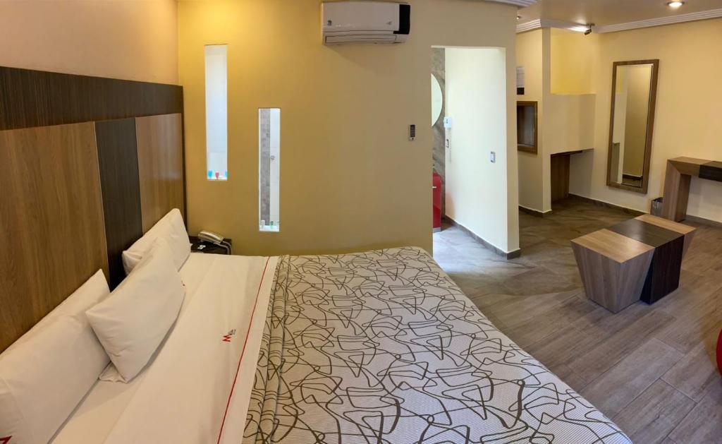 ein Schlafzimmer mit einem großen Bett und einem Schreibtisch. in der Unterkunft HOTEL M ELITE ROJO in Mexiko-Stadt