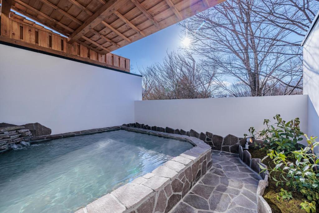 a swimming pool in a backyard with a pergola at Sengokuhara Shinanoki Ichinoyu in Hakone
