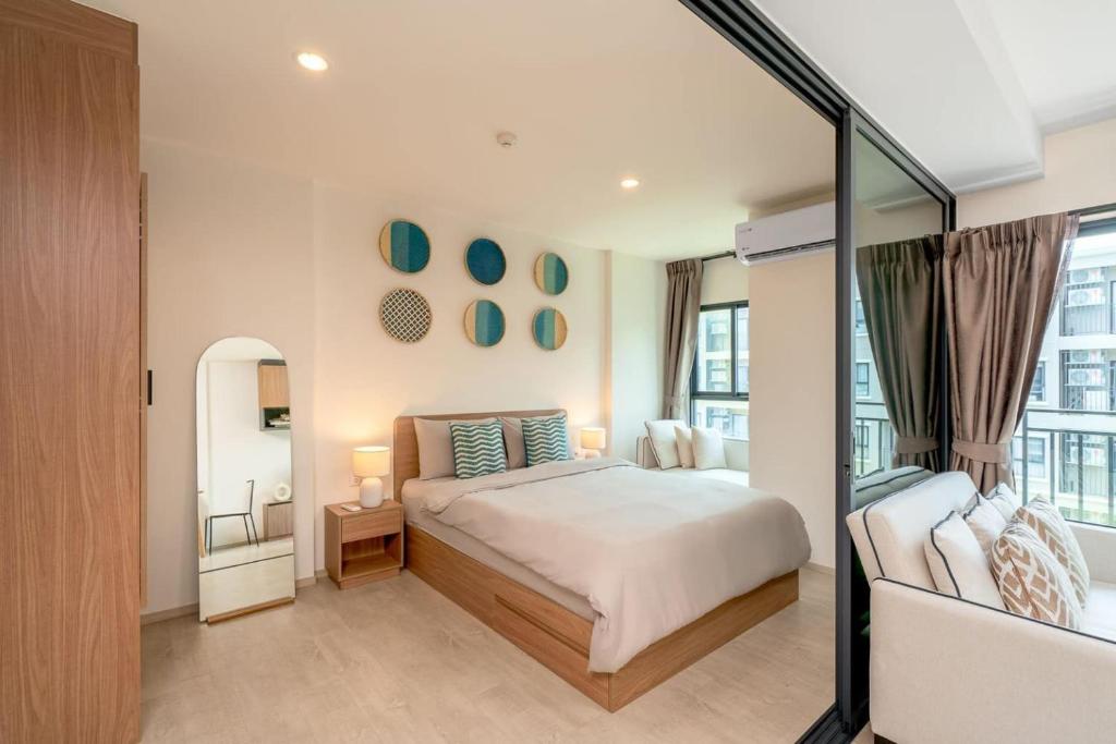 Schlafzimmer mit einem Bett und einem Spiegel in der Unterkunft Lacasita Near Beach Huahin (Room652) in Hua Hin