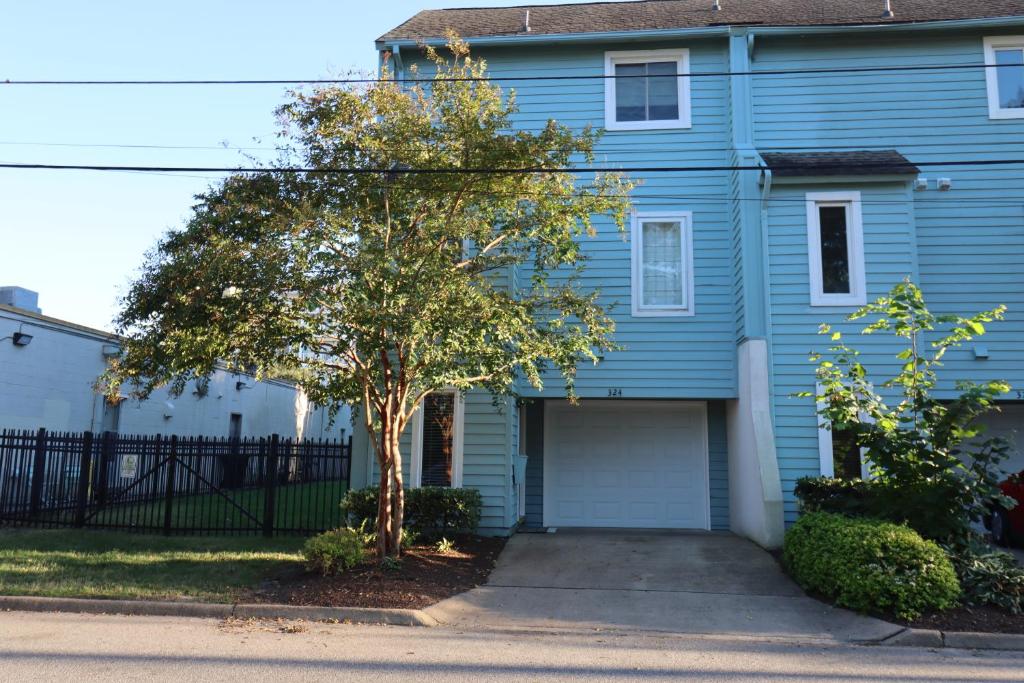 a blue house with a tree in front of it at Cheerful Beach Townhouse in Virginia Beach