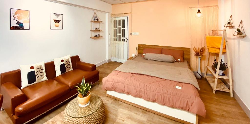 a bedroom with a bed and a couch at Lagom studio 18 - đẹp và yên bình, kế bên dinh độc lâp, nhà thờ Đức Bà, đường Nguyễn Du, phường Bến Nghé, Quận 1 in Ho Chi Minh City