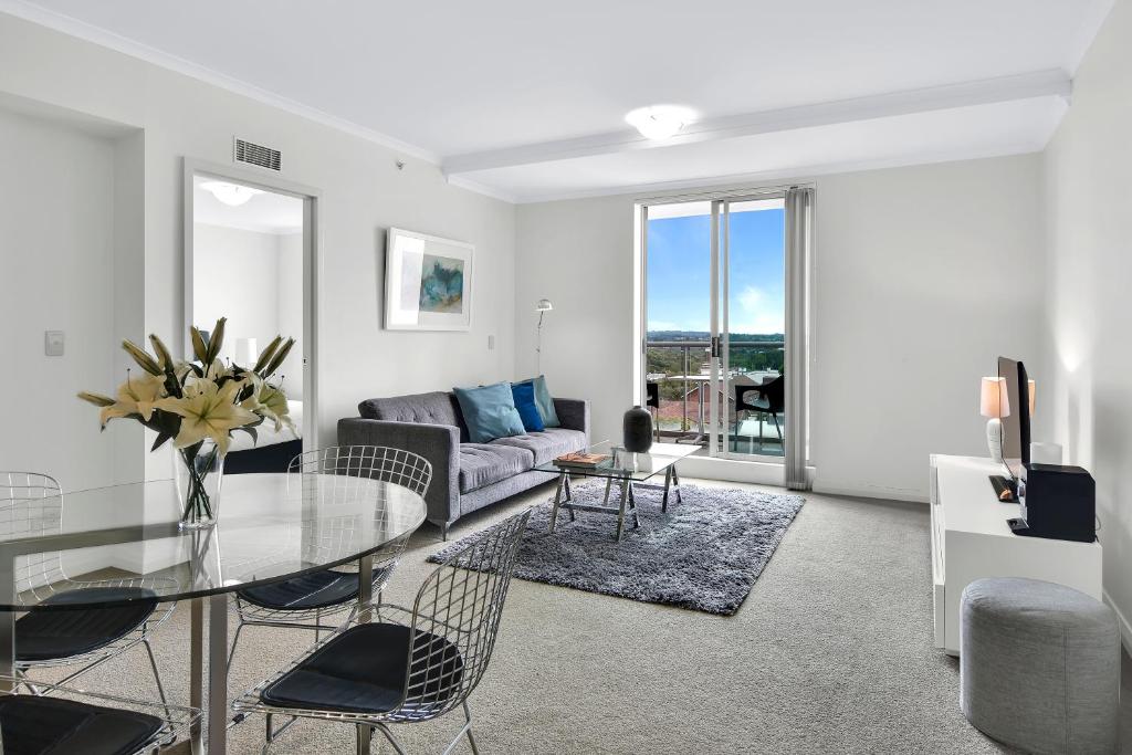 a living room with a glass table and a couch at Modern spacious Chatswood Apartment H1016 in Sydney