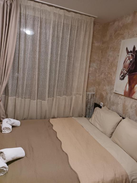 a bedroom with a bed with a horse picture on the wall at APARTAMENT-DAMO in Pamporovo