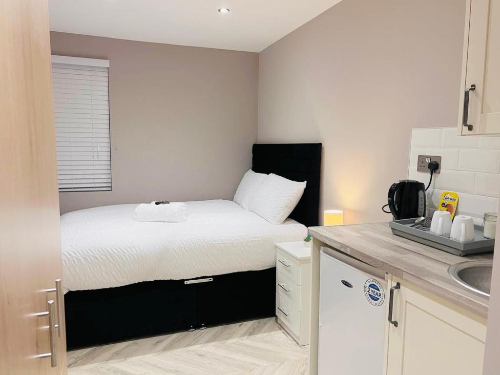 Dormitorio pequeño con cama y lavamanos en Cozzy, en Londres
