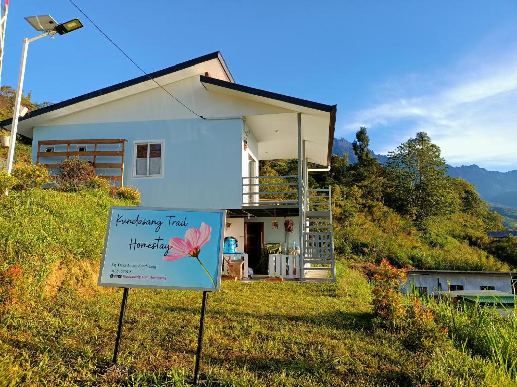 uma casa com um sinal em frente em Kundasang Trail Homestay em Kampong Kundassan