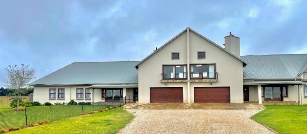 a large white house with a garage at On-Nkwe accommodation in Tierpoort
