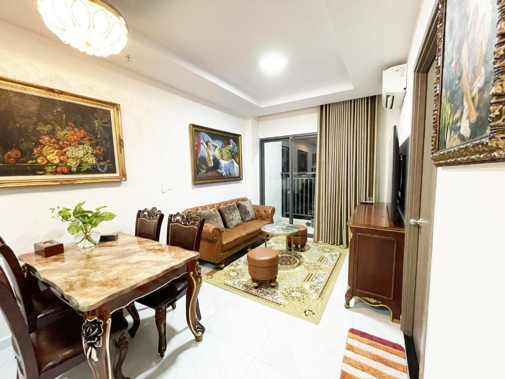 sala de estar con mesa y sofá en Ductaigallery's Apt& Pool-Good view, en Ấp Phú Thọ