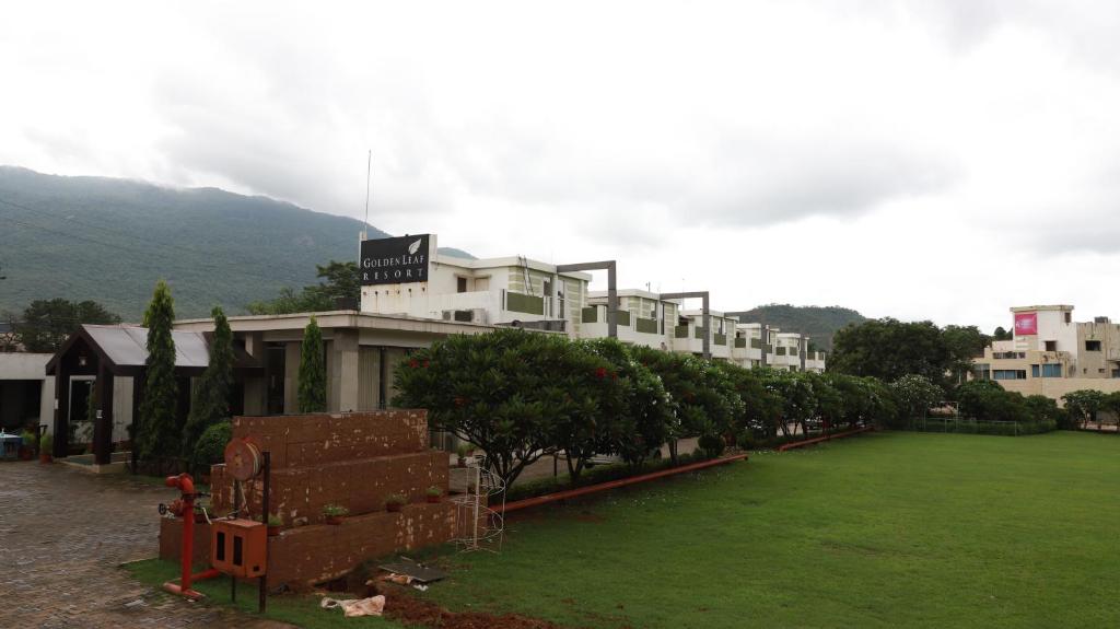 duży budynek z zielonym trawnikiem przed nim w obiekcie GOLDEN LEAF RESORT w mieście Surajgarha