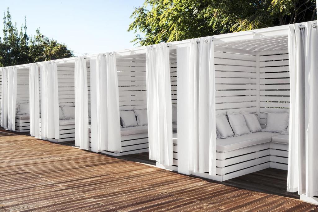 a row of white lounges on a wooden deck at La Suite Boutique Hotel in Procida