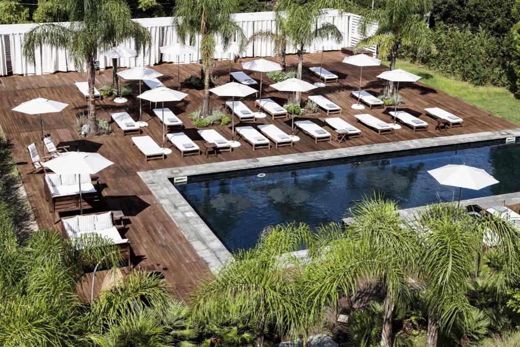 an overhead view of a pool with lounge chairs and umbrellas at La Suite Boutique Hotel in Procida