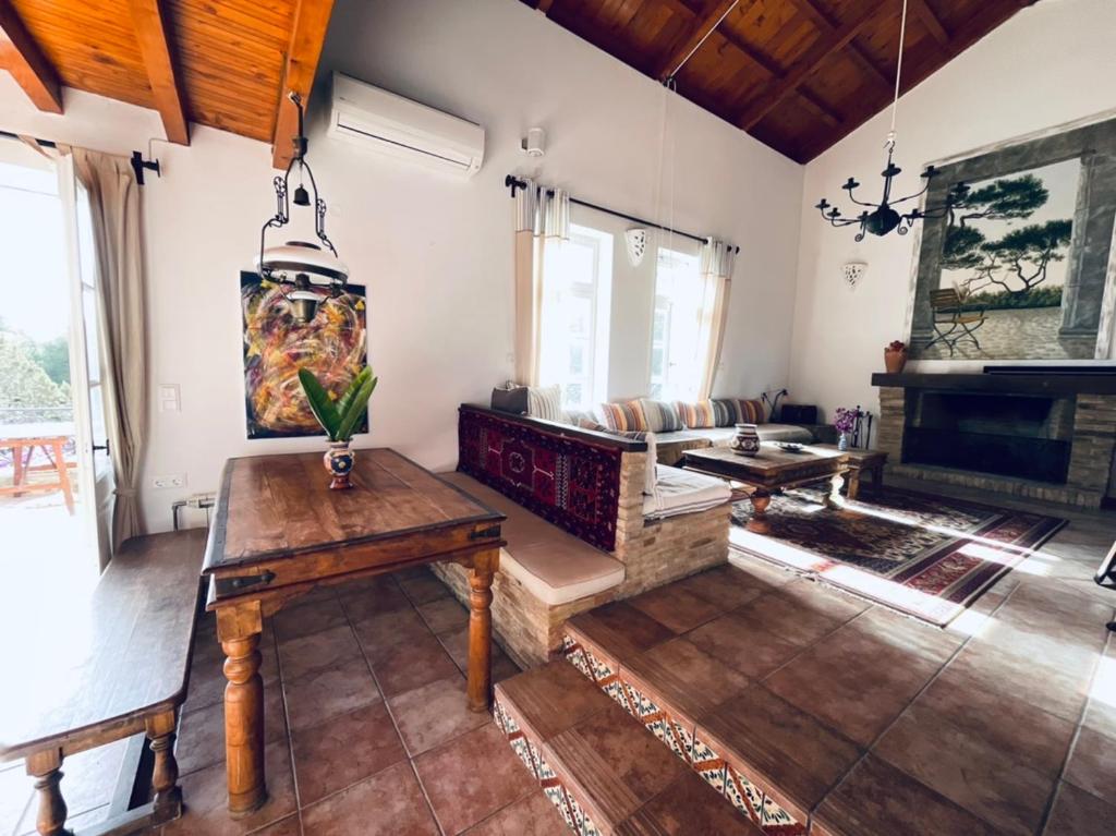 a living room with a table and a fireplace at Villa Conte in Panayías