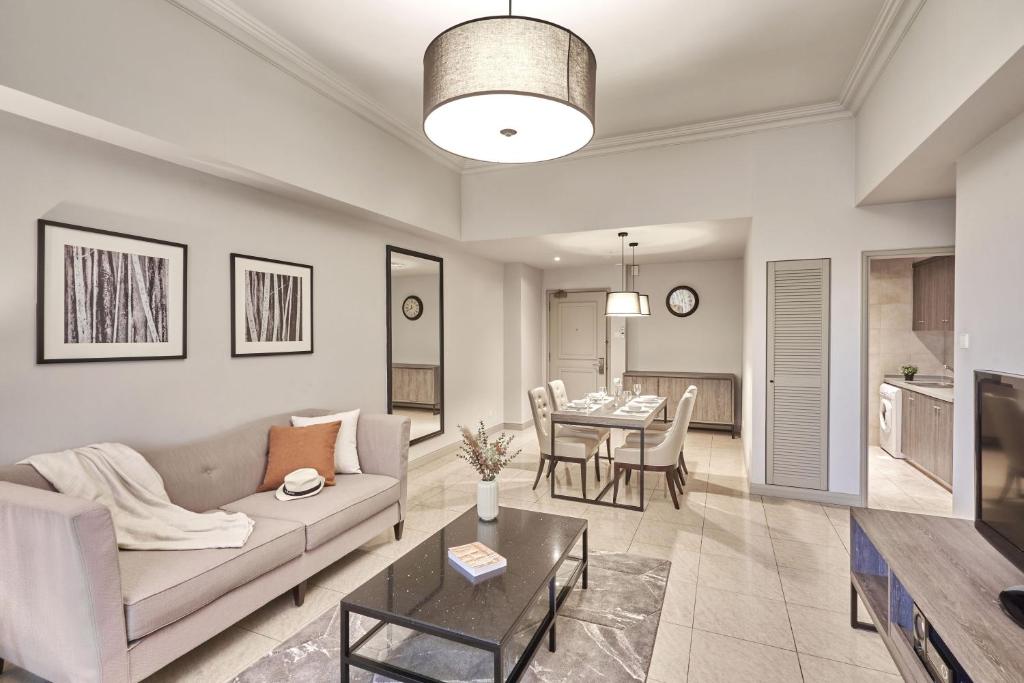 新加坡Adina Serviced Apartments Singapore Orchard的客厅里有一张沙发和一张桌子。