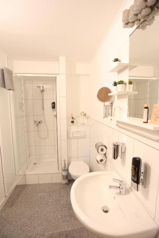 a white bathroom with a sink and a toilet at Pension Alte Scheune in Melsungen