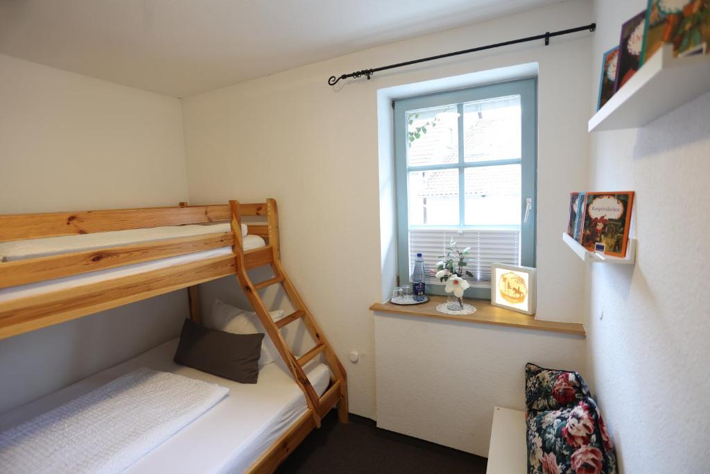 a bedroom with two bunk beds and a window at Pension Alte Scheune in Melsungen