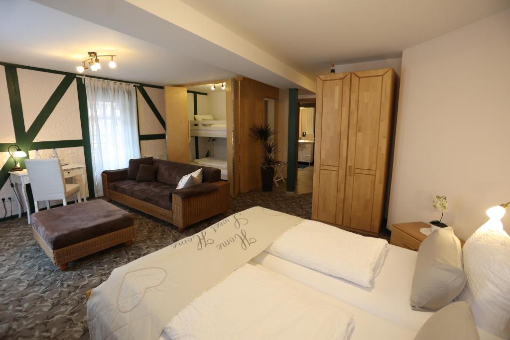 a hotel room with a bed and a living room at Pension Alte Scheune in Melsungen