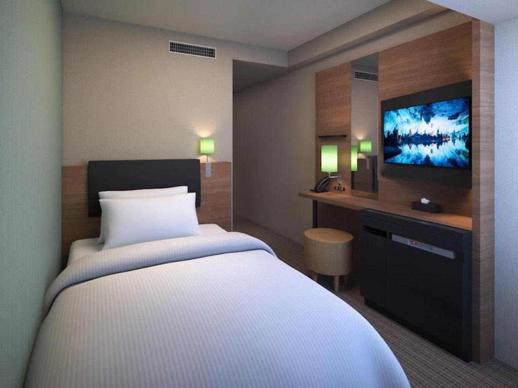 大阪Prince Smart Inn Osaka Yodoyabashi的一间配有床和平板电视的酒店房间