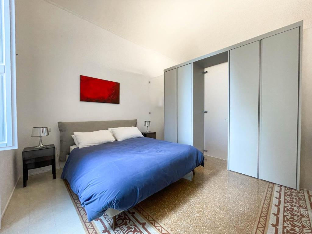 1 dormitorio con 1 cama y una pintura roja en la pared en L’arco di San Giuseppe en Siracusa