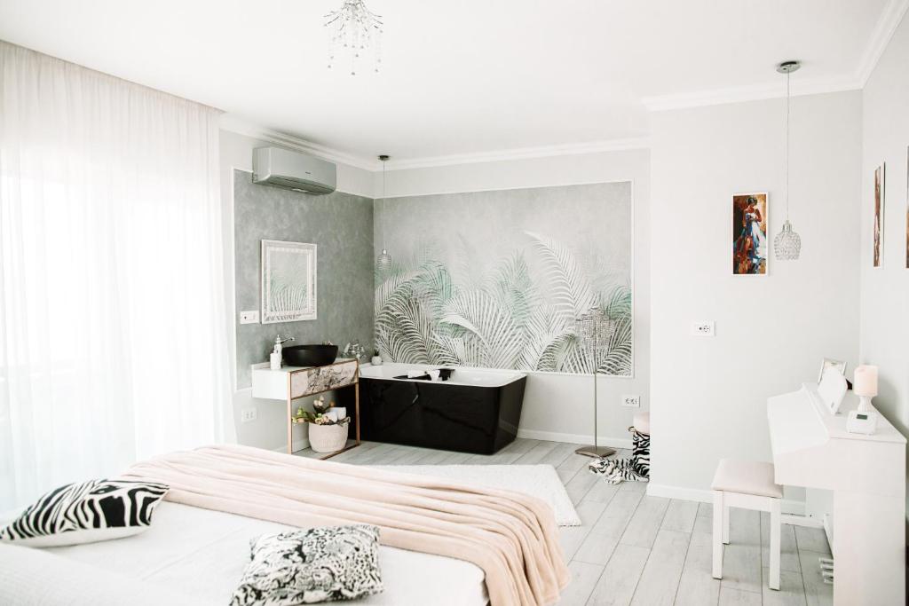 ein weißes Schlafzimmer mit einem Bett und einer Badewanne in der Unterkunft AM Apartments 13 Timisoara in Timişoara
