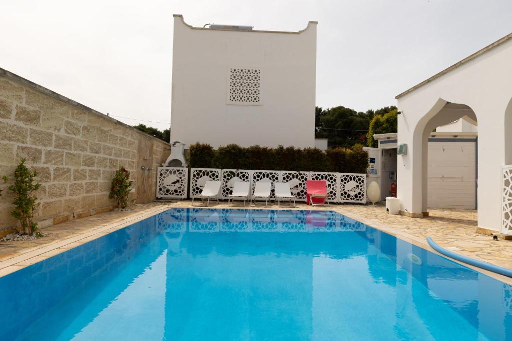 una piscina di fronte a un edificio bianco di Appartamento Playa Lapillo a Nardò