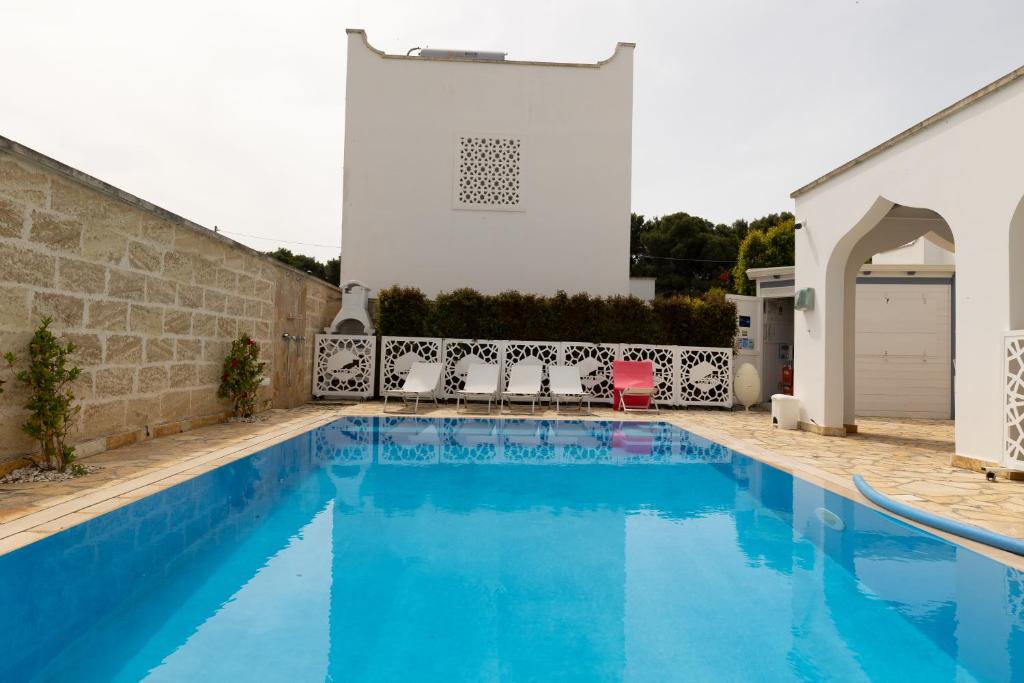 a swimming pool in front of a white building at Appartamento Playa Lapillo in Nardò