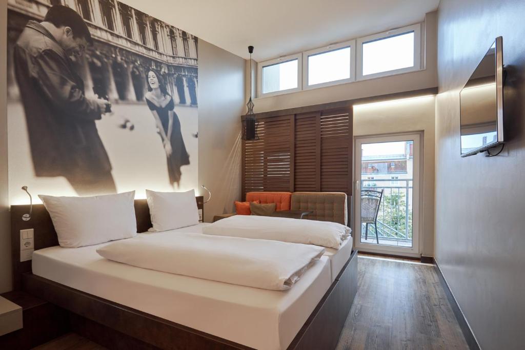 a bedroom with two beds and a window at Hotel GIO in Munich