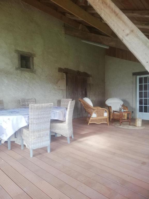 a patio with wicker chairs and a table and a table and chairs at Gite de la haute roche in Charroux