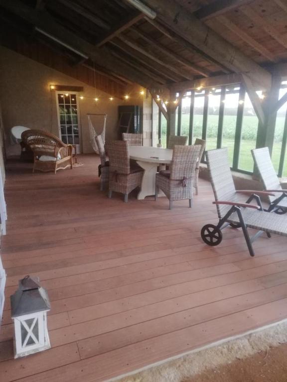 a patio with chairs and a table on a wooden deck at Gite de la haute roche in Charroux