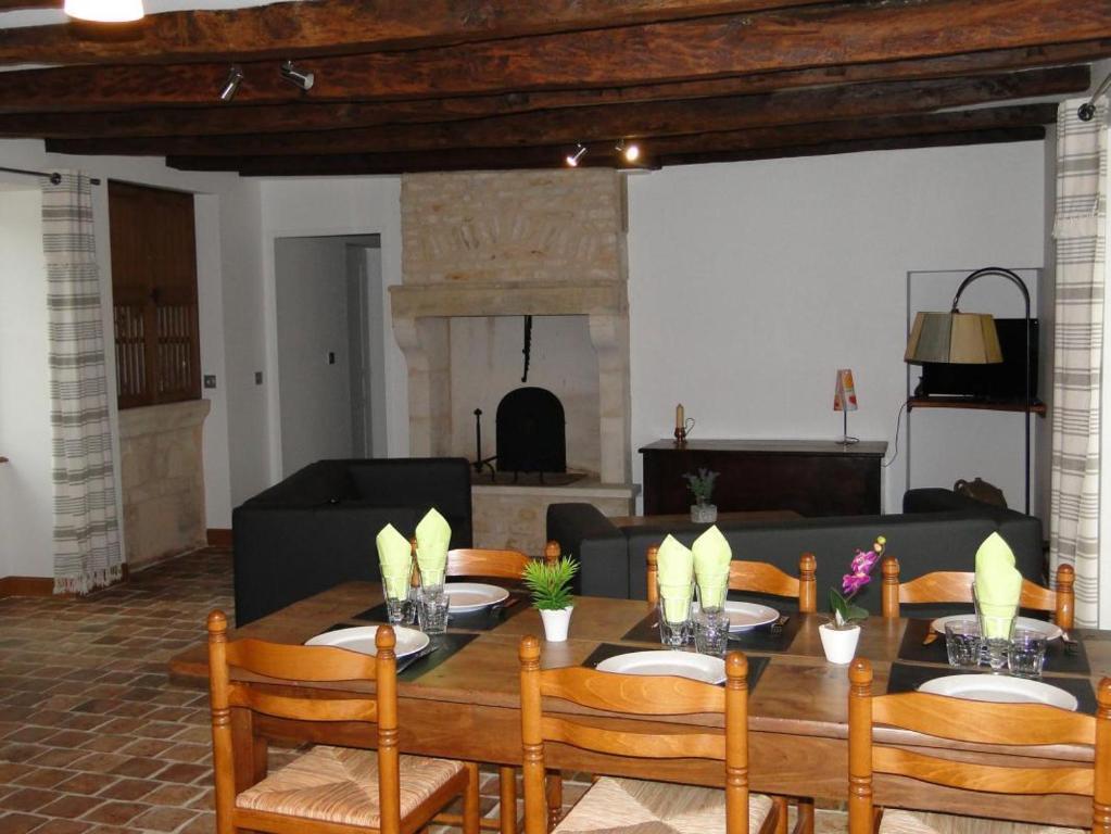 uma sala de jantar com uma mesa e um sofá em Gite du pont de maille em Saint-Martin-lʼArs