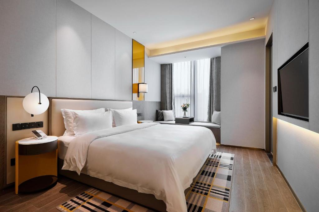 Postel nebo postele na pokoji v ubytování Qingdao Oriental Studio Chuangzhi SSAW Hotel