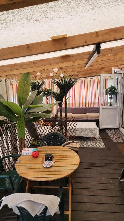 a wooden patio with a wooden table and chairs at Mobil home 6 personnes Forêt des landes in Mimizan