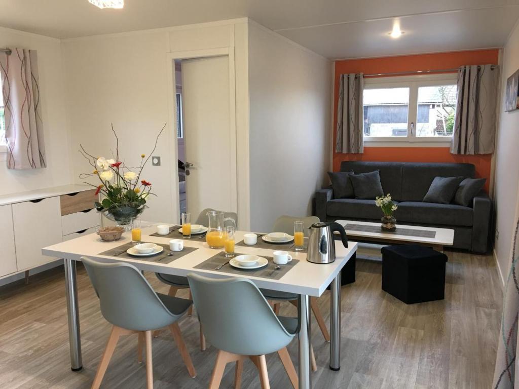uma cozinha e sala de estar com uma mesa branca e cadeiras em Mandarine la vallee des noyers em Lhommaizé