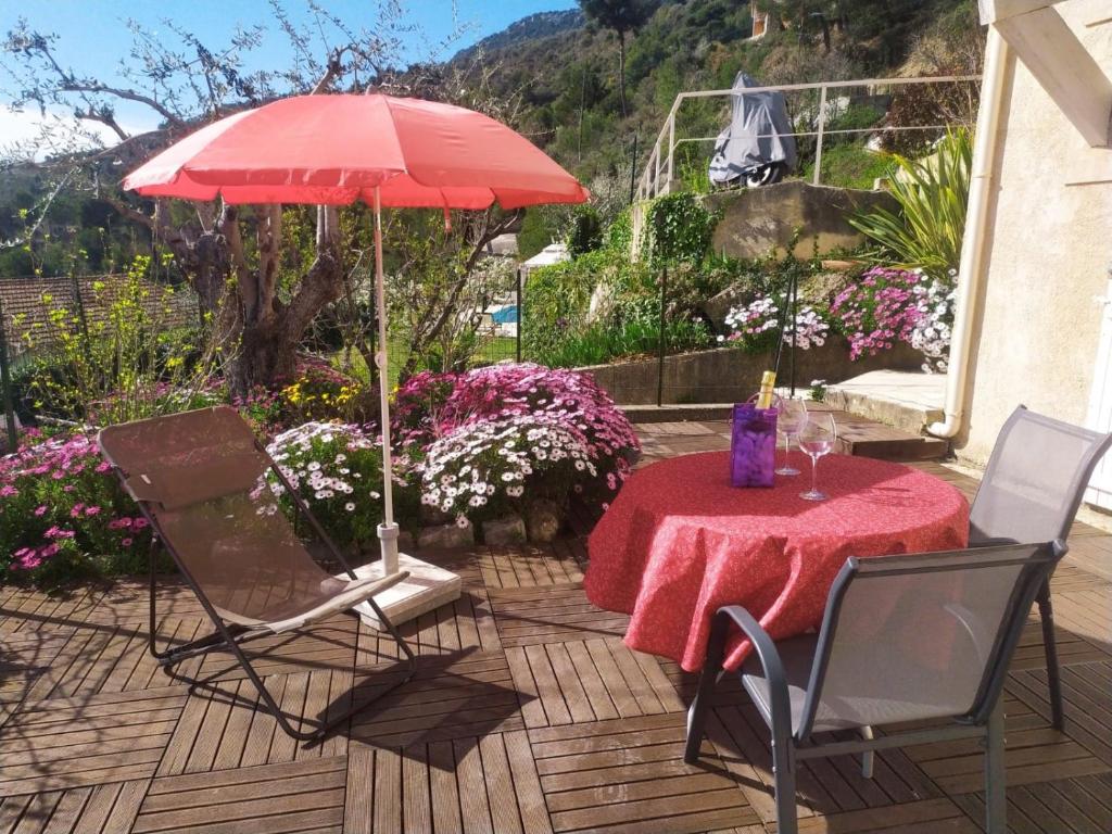 una mesa con un mantel rojo y una sombrilla roja en Studio le romantique à 20 kms de Nice, en Bendéjun