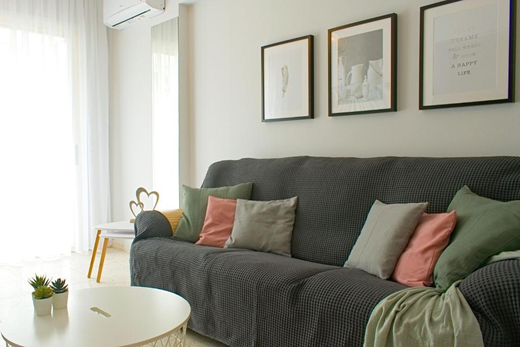 a living room with a gray couch with colorful pillows at ALEX APARTMENT in Strovolos