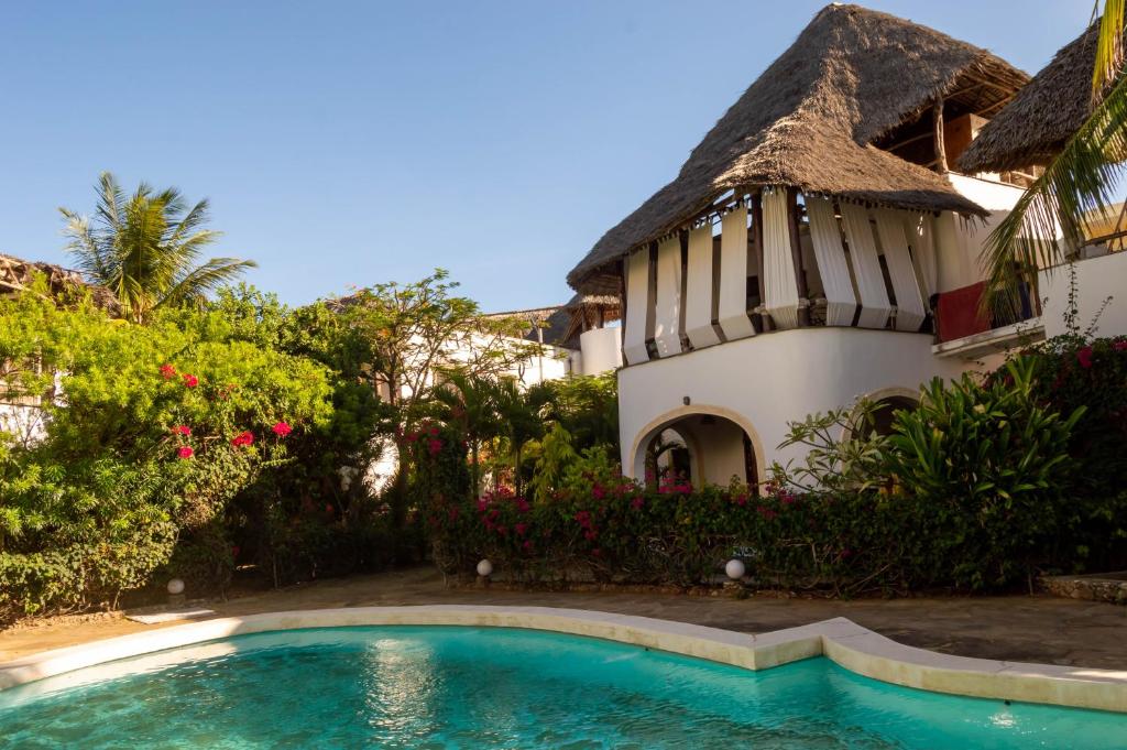 a house with a swimming pool next to a building at Rischland Villas in Watamu