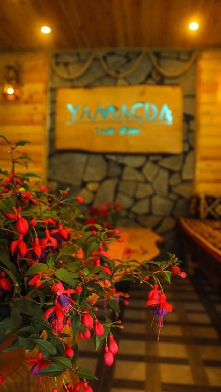 a plant with red flowers in a room with a sign at Yamacda Suit Otel in Çamlıhemşin