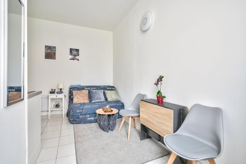 a bedroom with a bed and a table and chairs at Magnificent studio near Paris in Clichy
