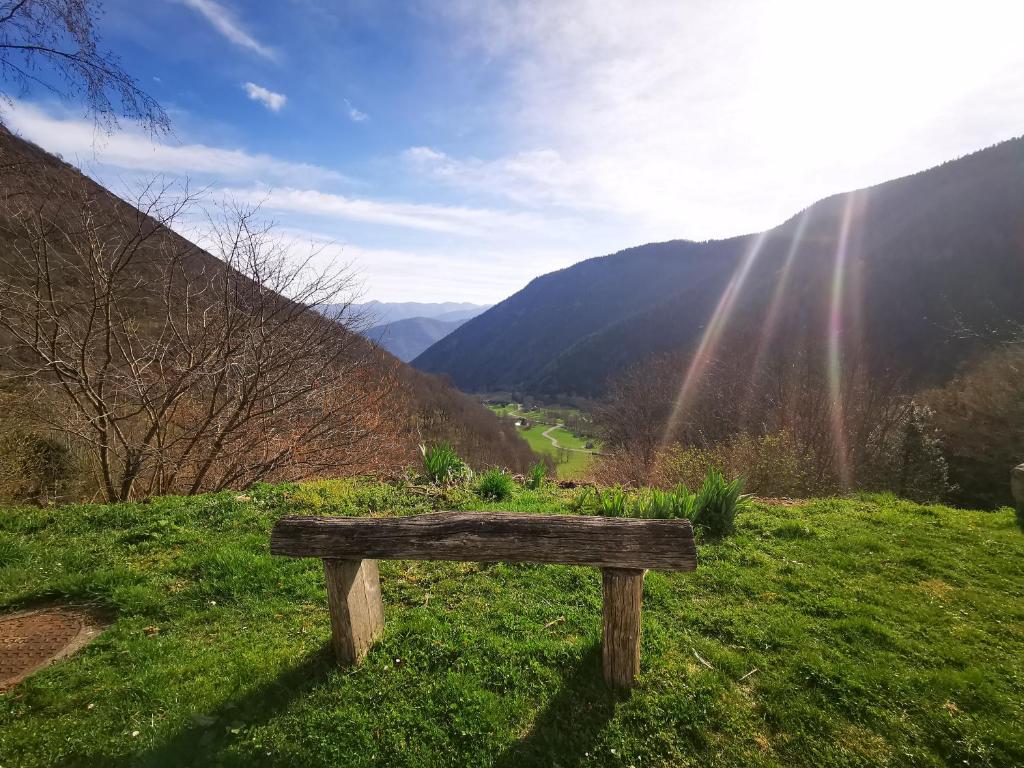 un banc en bois assis au sommet d'une colline herbeuse dans l'établissement Maison Aulon (Saint Lary), à Aulon