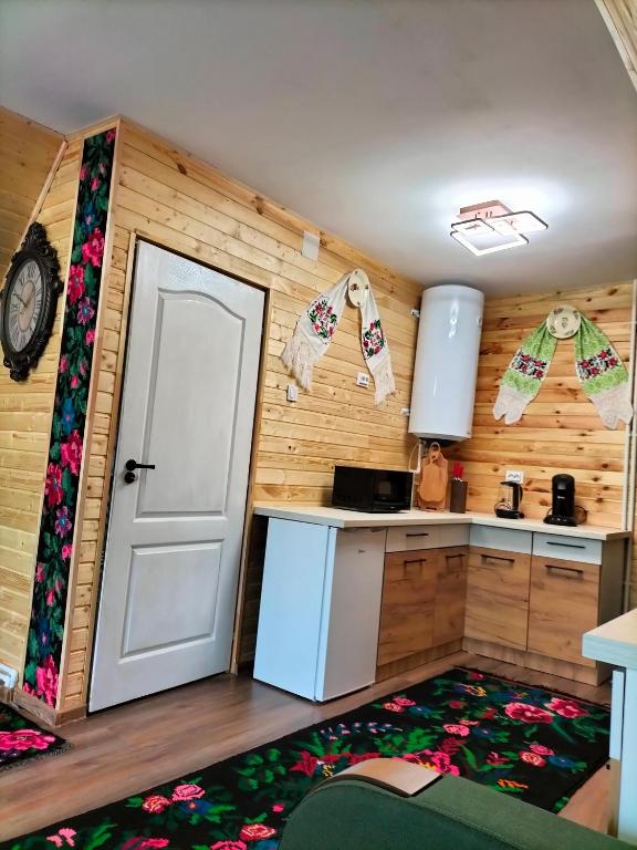 a small kitchen with a white door and a kitchen rug at A frame Sima in Breb