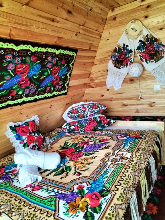 a bed in a room with a blanket and pillows at A frame Sima in Breb
